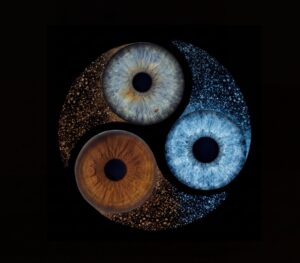 Artistic "Iris Photography" composition: three human eye irises (blue, brown, yellowish) forming a vibrant tricolor swirl on a black background. This meaningful piece is part of the iris art online collection, symbolizing soul harmony and spiritual resonance. Order your online iris scan now.