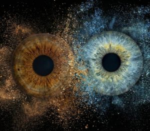 Popular "Iris Art online" piece "Eternal Spark": two human eye irises (brown and light grey) surrounded by a powerful blue and yellowish dust cloud effect against a black background. This meaningful piece is part of the iris art online collection, symbolizing eternal love and spiritual connection. Order your online iris scan now.