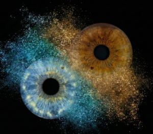 Mystical "Iris Photography" artwork "Midnight Storm": two human eye irises (brown and light grey) surrounded by a powerful blue and yellowish smoke and dust explosion effect against a black background. This is unique iris art online, transforming the beauty of your eyes into an energetic masterpiece. The online iris service allows you to order such personalized artworks online.