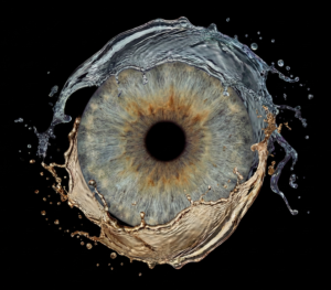 Vibrant greenish-brown human eye iris macro art merged with a dynamic water splash and droplet effect on a black background. This meaningful piece is part of the iris art online collection, symbolizing natural life and spiritual purity. Order your online iris scan now.