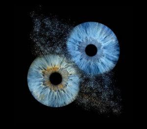 Unique Iris Photography artwork: two blue human eye irises on a black background, merged by a dramatic dust explosion effect. Detailed macro photography highlighting individual iris patterns, perfect for modern interiors and personalized gifts.